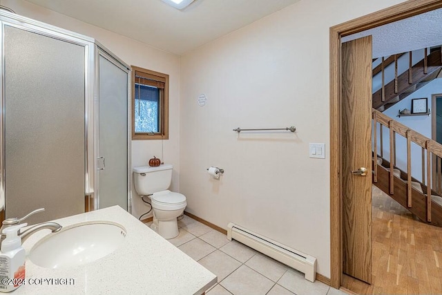 bathroom with a shower with door, tile patterned floors, sink, toilet, and a baseboard radiator