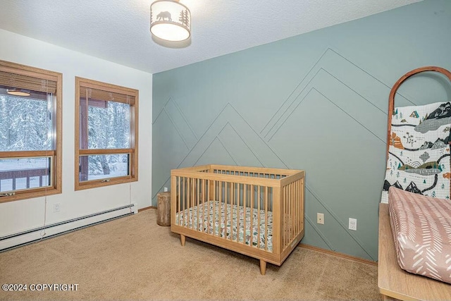 carpeted bedroom featuring a baseboard heating unit, a textured ceiling, and a nursery area