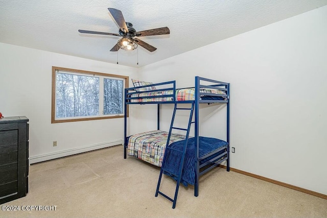 bedroom with a textured ceiling, ceiling fan, light carpet, and a baseboard radiator