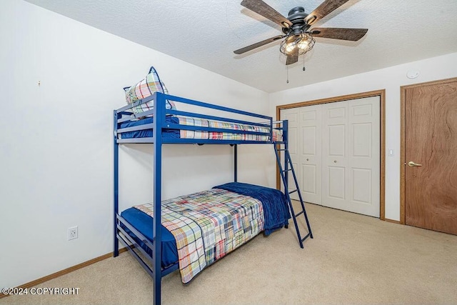 bedroom with light carpet, a textured ceiling, a closet, and ceiling fan