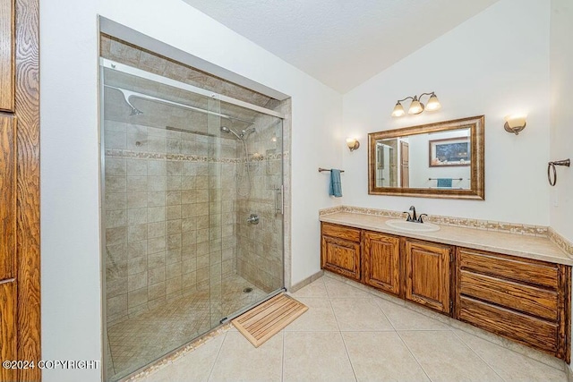 bathroom featuring tile patterned flooring, vanity, a shower with shower door, and vaulted ceiling