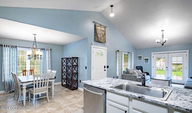 5169 Reliance Rd, Wasilla, AK 99654 - kitchen featuring a chandelier, stainless steel dishwasher, white cabinetry, open floor plan, and high vaulted ceiling