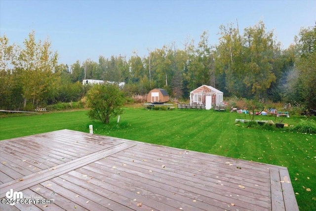 wooden deck with a storage shed and a yard