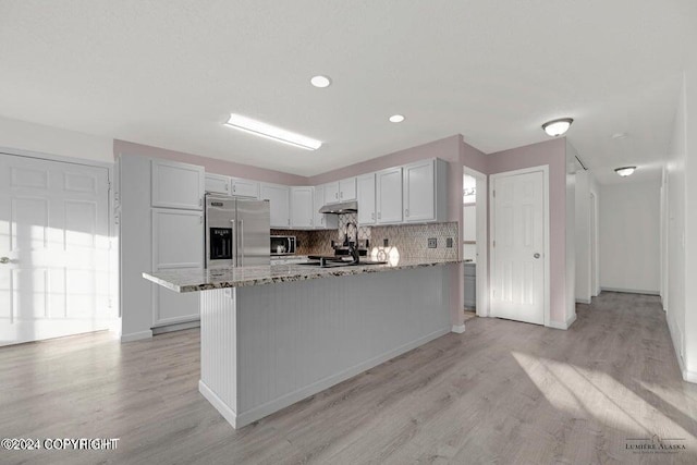 5169 Reliance Rd, Wasilla, AK 99654 - kitchen featuring stainless steel appliances, light stone countertops, light wood-style floors, under cabinet range hood, and recessed lighting