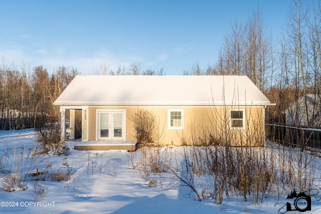 snow covered house featuring french doors