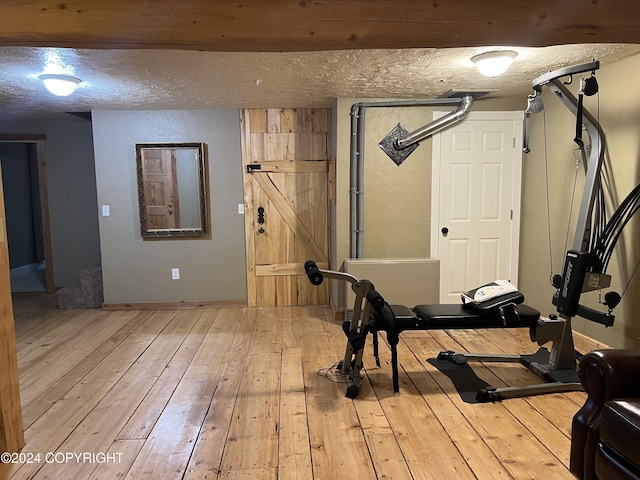 38400 Robinson Loop Rd, Sterling, AK 99672 - workout room with hardwood / wood-style flooring and a textured ceiling