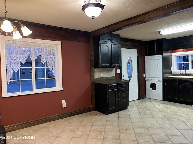 38400 Robinson Loop Rd, Sterling, AK 99672 - kitchen featuring stacked washer / dryer, a sink, dark cabinets, beam ceiling, and a textured ceiling