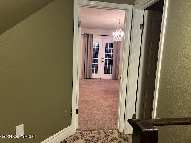 38400 Robinson Loop Rd, Sterling, AK 99672 - hallway featuring carpet flooring, a textured wall, a chandelier, and french doors