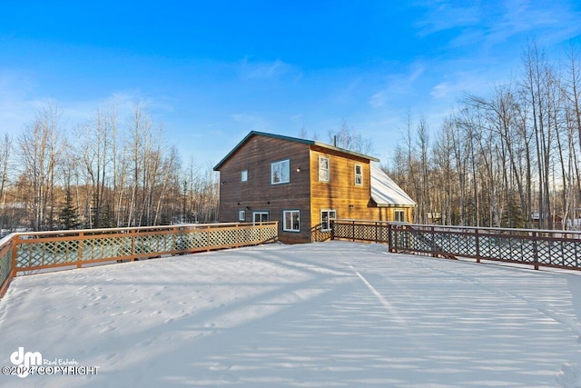 view of snow covered back of property