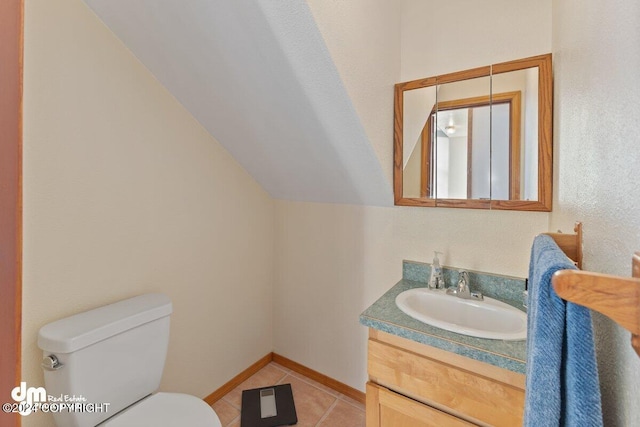 bathroom featuring tile patterned floors, vanity, toilet, and lofted ceiling