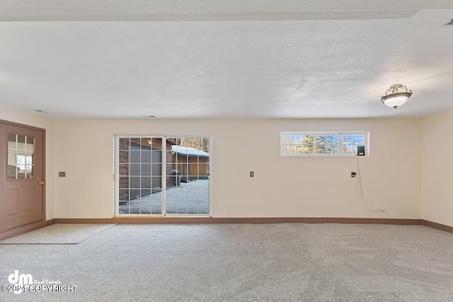 carpeted spare room featuring a textured ceiling