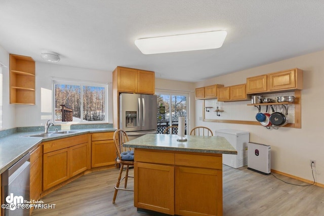 kitchen with a center island, light hardwood / wood-style flooring, appliances with stainless steel finishes, and sink