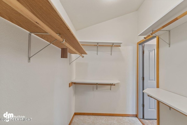 walk in closet featuring vaulted ceiling