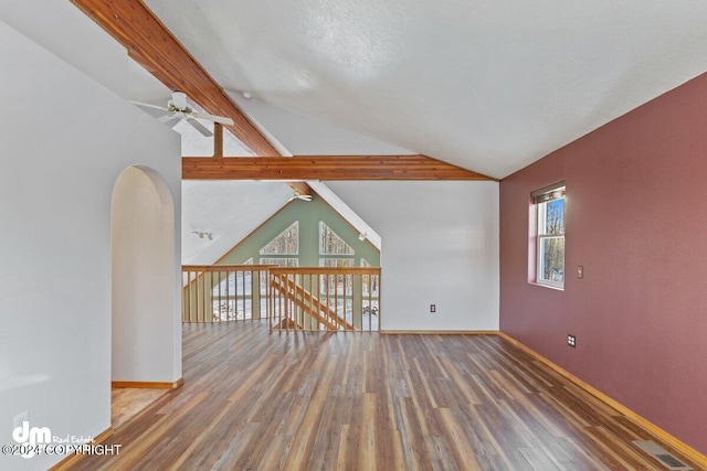 empty room featuring beam ceiling, high vaulted ceiling, ceiling fan, and dark wood-type flooring