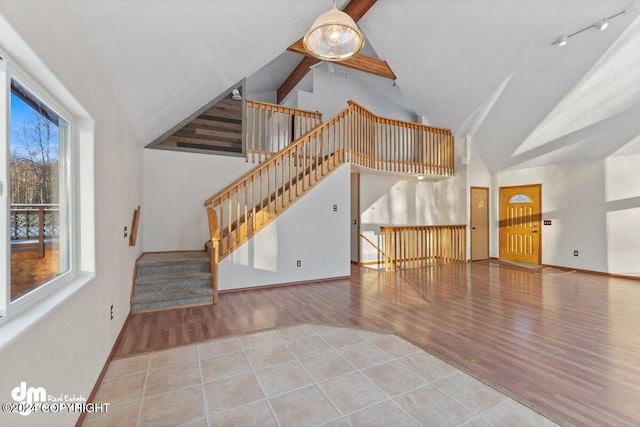 unfurnished living room featuring light hardwood / wood-style flooring, a wealth of natural light, and lofted ceiling