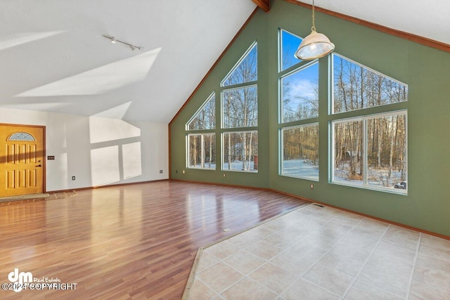 additional living space with beam ceiling, hardwood / wood-style floors, and high vaulted ceiling