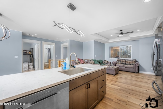 kitchen featuring hanging light fixtures, sink, ceiling fan, light wood-type flooring, and appliances with stainless steel finishes