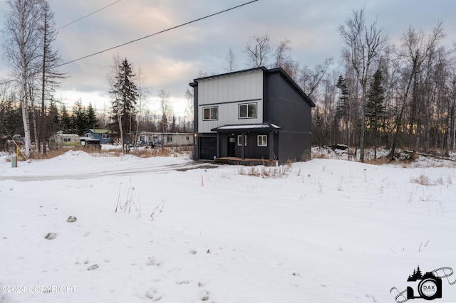 view of snow covered back of property