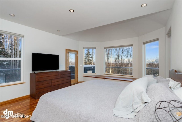 bedroom with light hardwood / wood-style flooring and multiple windows