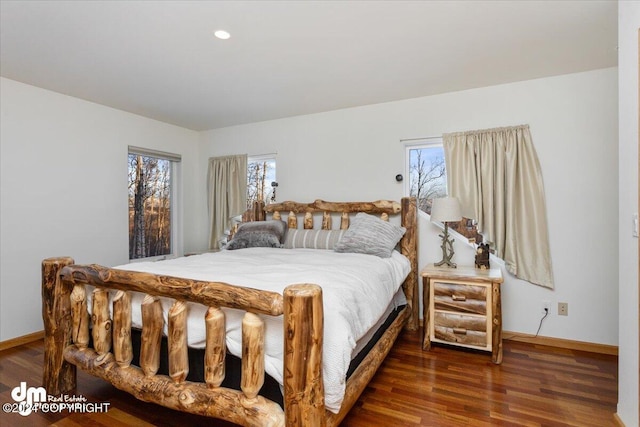 bedroom featuring multiple windows and dark hardwood / wood-style flooring