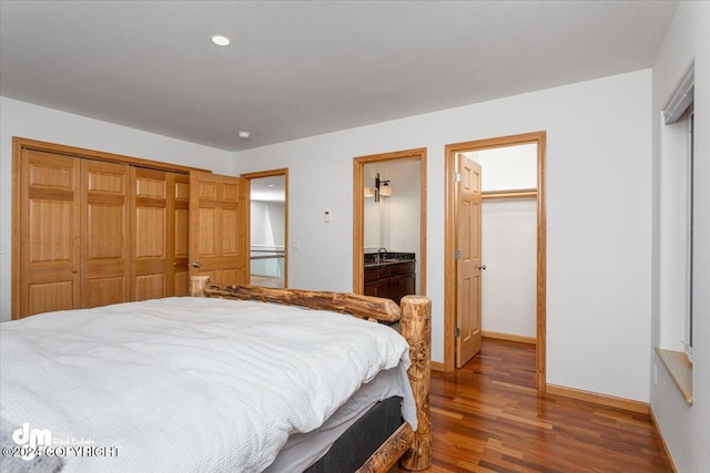 bedroom featuring sink, dark wood-type flooring, and ensuite bath