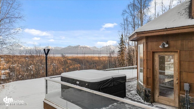 snow covered deck with a mountain view