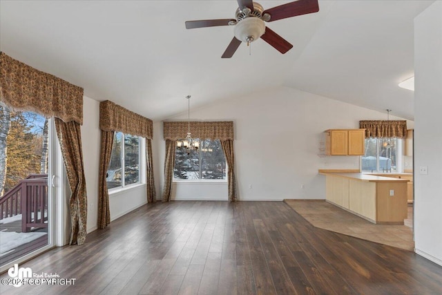 unfurnished living room with dark hardwood / wood-style floors, sink, lofted ceiling, and ceiling fan with notable chandelier