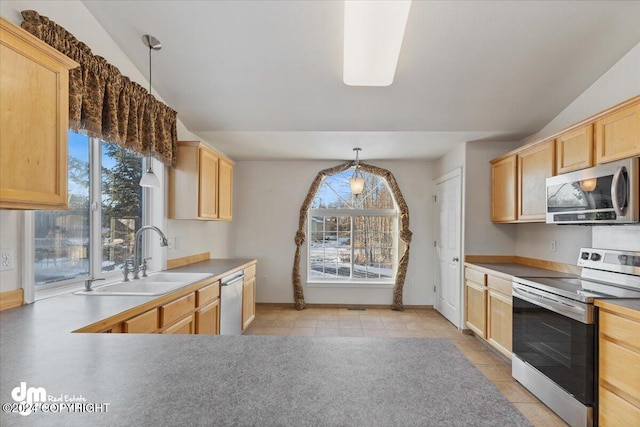 kitchen featuring light brown cabinetry, stainless steel appliances, hanging light fixtures, and sink