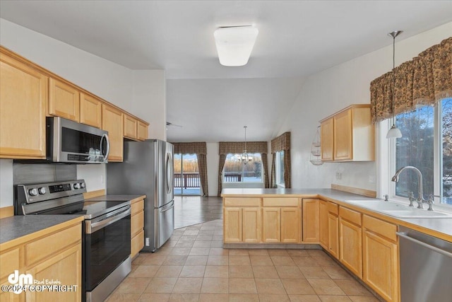 kitchen featuring sink, a notable chandelier, kitchen peninsula, pendant lighting, and appliances with stainless steel finishes