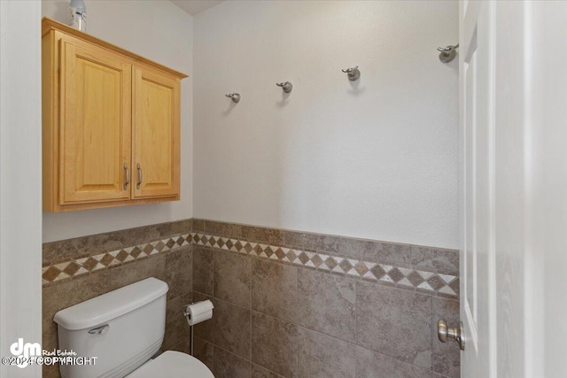 bathroom with tile walls and toilet