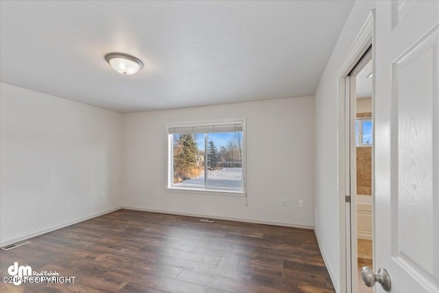 spare room with dark hardwood / wood-style flooring