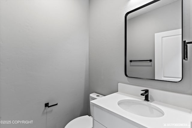 bathroom featuring vanity and toilet