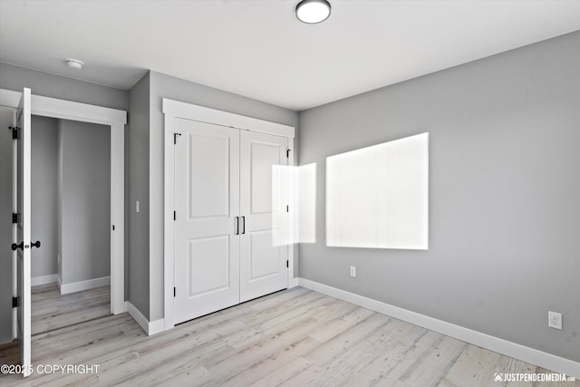 unfurnished bedroom with a closet and light wood-type flooring