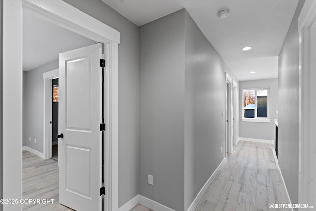 hallway with light hardwood / wood-style floors