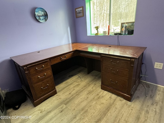 office with built in desk and light wood-type flooring