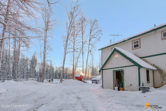 snow covered property with an outbuilding