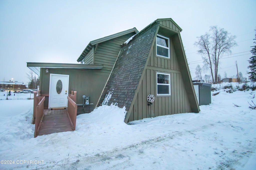 view of snow covered back of property