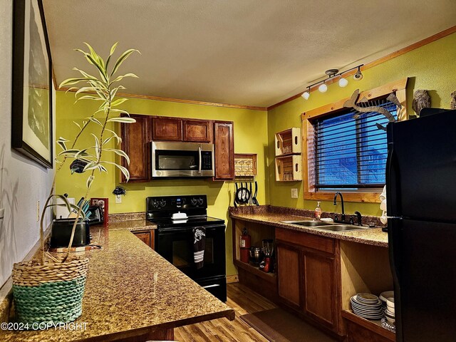 kitchen featuring black appliances, sink, ornamental molding, dark hardwood / wood-style flooring, and light stone counters