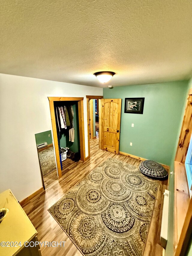 bedroom with wood-type flooring and a textured ceiling