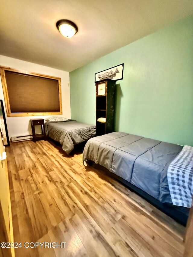 bedroom featuring light hardwood / wood-style floors and a baseboard radiator