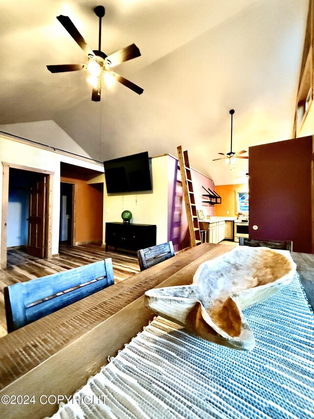 living room with hardwood / wood-style floors, ceiling fan, and lofted ceiling