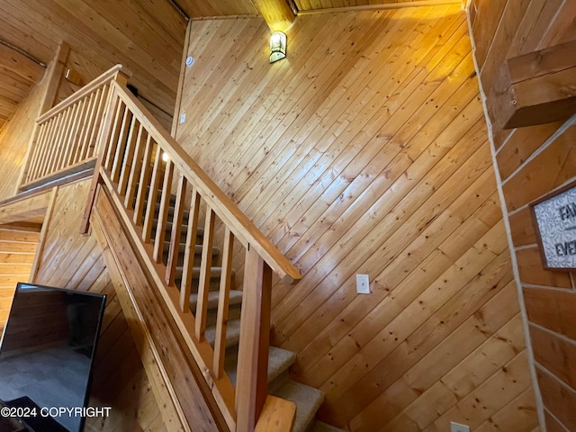 stairway with vaulted ceiling and wooden walls