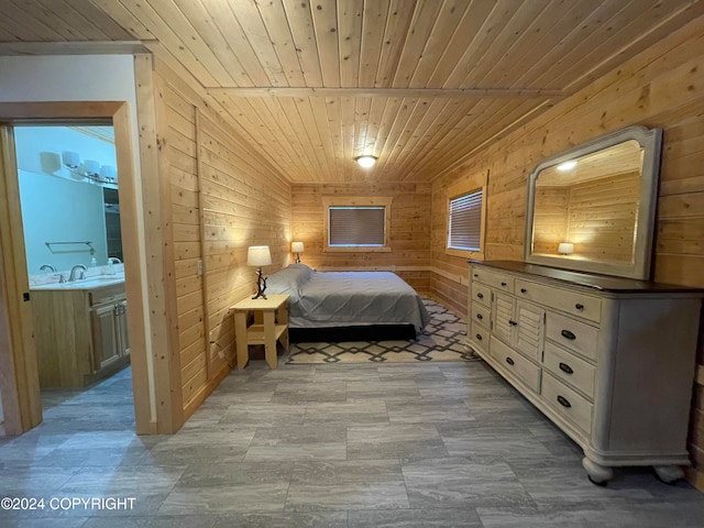 bedroom featuring sink, ensuite bathroom, wooden walls, and wood ceiling