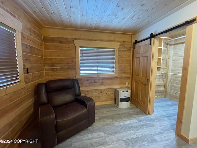 living area featuring a barn door, wood walls, and wooden ceiling