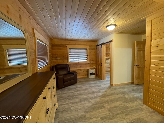 living area featuring a barn door, heating unit, wooden ceiling, and wood walls