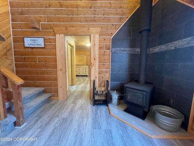 bathroom with hardwood / wood-style floors, a wood stove, and wood walls