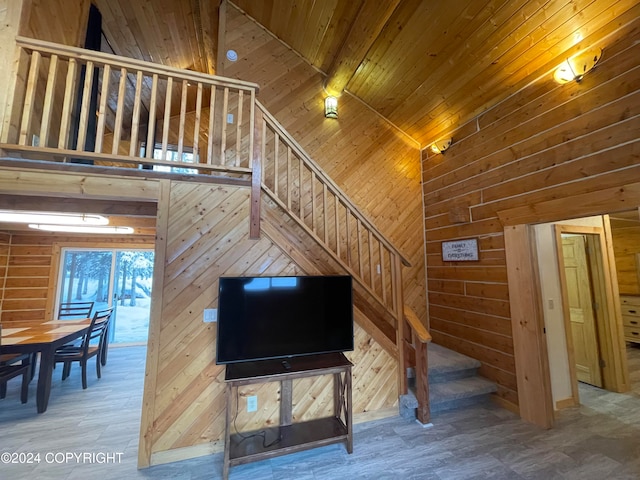 interior space with hardwood / wood-style flooring, wood walls, wood ceiling, and a high ceiling