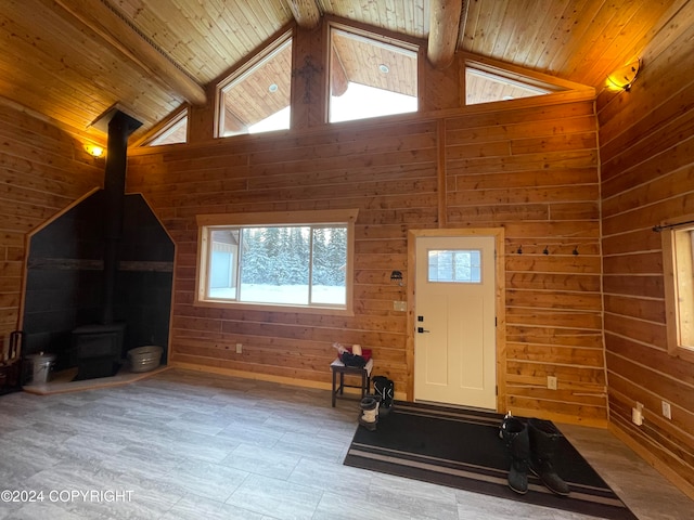 workout room featuring a wood stove, wooden walls, high vaulted ceiling, and wooden ceiling