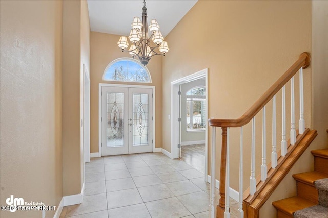 tiled foyer entrance featuring a chandelier and french doors