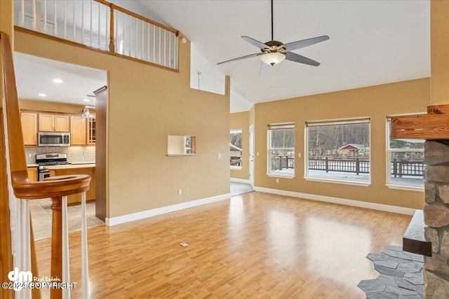 living room with light hardwood / wood-style flooring, ceiling fan, and lofted ceiling